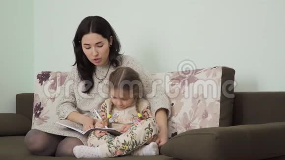 年轻女子帮助女儿做家庭作业视频的预览图
