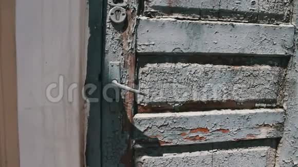 街上一扇门上有灰色油漆的老式木器破旧视频的预览图