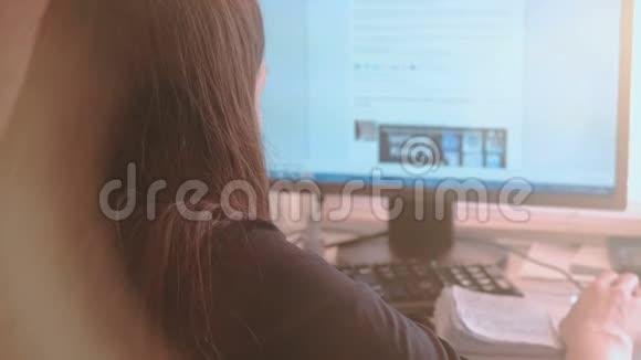 在电脑上工作年轻女子在屏幕上浏览互联网页面后景视频的预览图