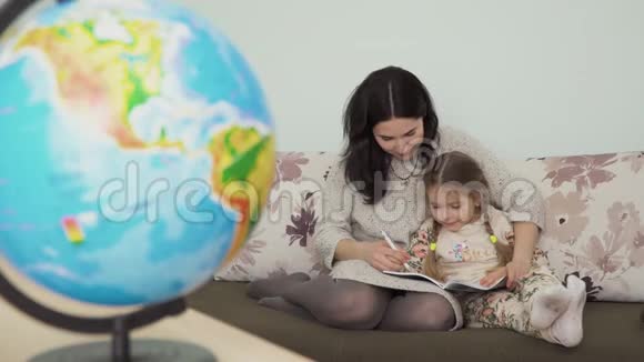 年轻女子帮助她的小女儿做家庭作业视频的预览图