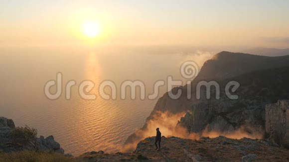 在克里米亚的一座高山上年轻女子在海面上观看美丽的戏剧性日落视频的预览图