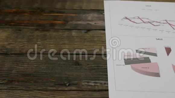 一张木桌上放着图表的纸滑块摄像机的运动视频的预览图
