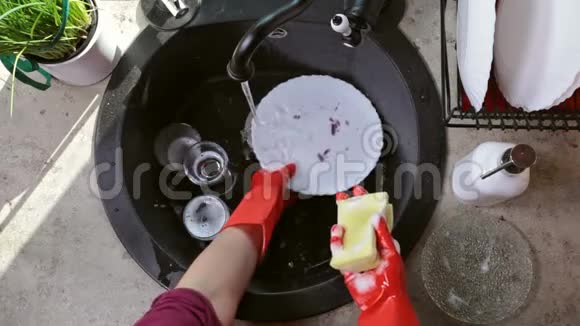 女人用橡胶手套洗碗视频的预览图
