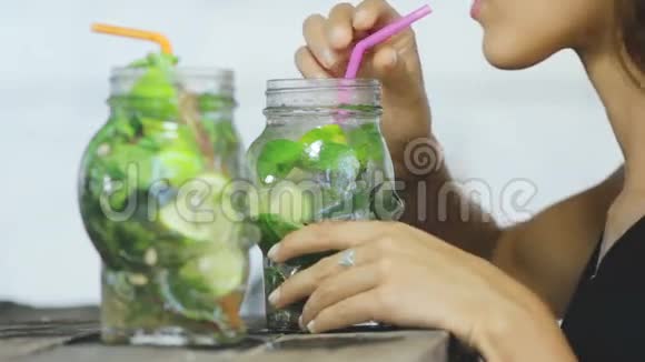 一个女人喝着热带莫吉托鸡尾酒视频的预览图