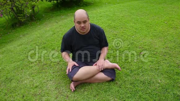 一个肥胖的秃头亚洲泰国男人像一个坏孩子一样生气然后在高清绿色草地上剧烈地扭动视频的预览图