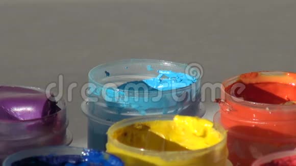 刷子浸在一罐蓝色青色丙烯酸水粉颜料中家庭视频的预览图