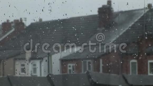 在沉闷的雪天透过窗户向英格兰的露台房屋望去视频的预览图