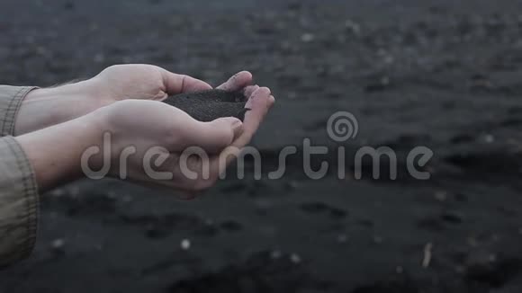 冰岛黑沙男人的手紧紧一把火山沙视频的预览图