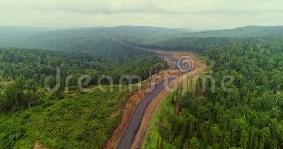 森林道路全景在森林中的乡村道路上的跳伞者的空中视野从泰加无人机的视野视频的预览图