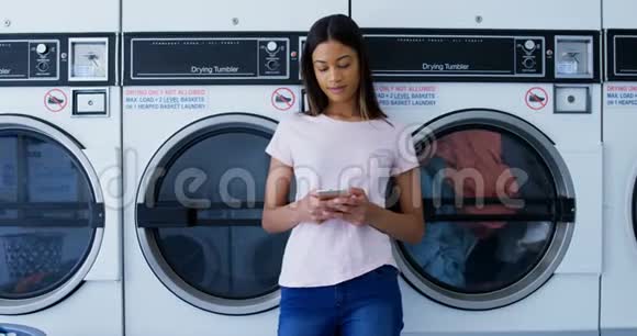 使用4k自助洗衣店手机的妇女视频的预览图