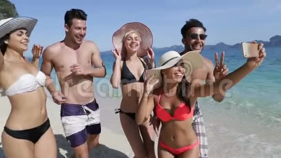 人们在海滩上的手机上自拍在度假时微笑的年轻游客团体视频的预览图