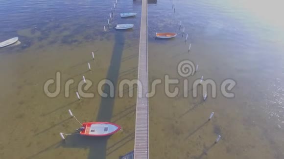 木制码头及附属船只的鸟瞰图视频的预览图