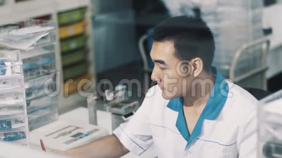 穿白色长袍的亚洲验光师在工作场所管理眼镜视频的预览图