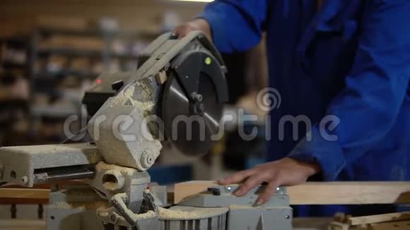 锯板用电锯工人在车间锯木板视频的预览图