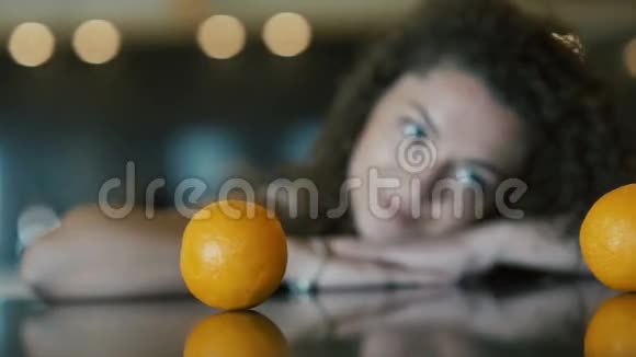 可爱的女孩看着桌上的橘子视频的预览图
