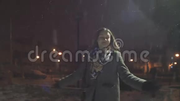 年轻快乐的女孩正在享受着雪花举起的双手视频的预览图