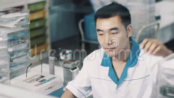 穿着白色长袍的亚洲眼镜商在工作场所管理眼镜视频的预览图