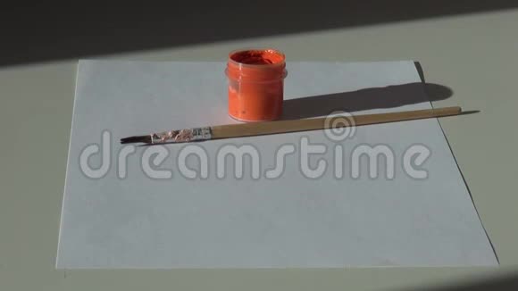 纸刷子和一罐橘黄色的丙烯酸水粉颜料在ta上视频的预览图