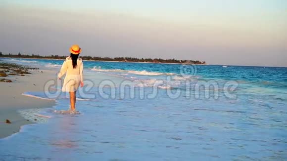 美丽的女人在白色海滩的暑假快乐的女孩穿着夏天的衣服散步流动人口视频的预览图