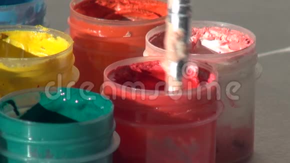 刷子浸在一罐红色丙烯酸水粉颜料中家庭作业视频的预览图