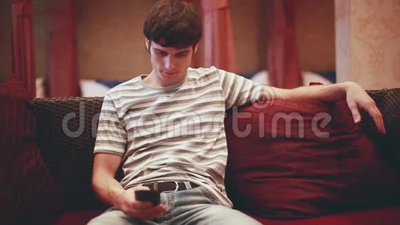 男人坐在沙发上在智能手机上浏览互联网1920x1080高清高清视频的预览图
