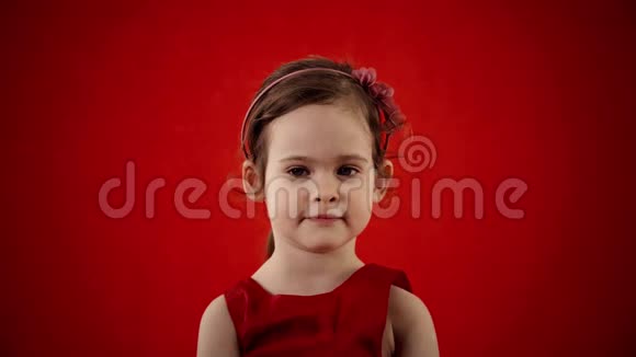 在红色背景下做鬼脸的女孩视频的预览图