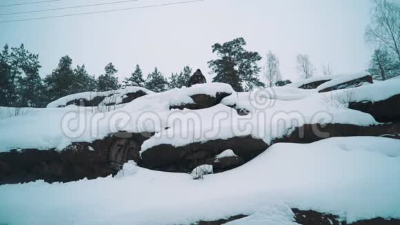 年轻的徒步旅行者爬雪覆盖的岩石悬崖边视频的预览图