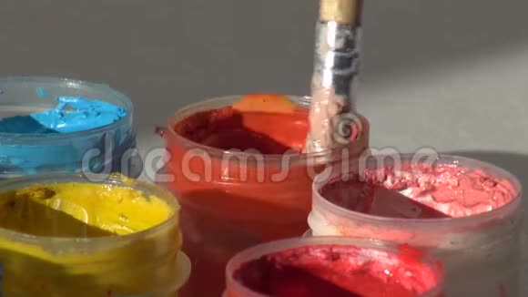 刷子浸在一罐橙色的丙烯酸水粉颜料中家庭主妇视频的预览图