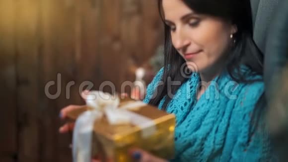 微笑的黑发女人打开圣诞树灯的礼盒视频的预览图