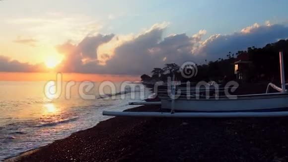 巴厘岛的传统船在海滩边日出视频的预览图