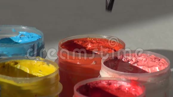 刷子浸在一罐橙色的丙烯酸水粉颜料中家庭主妇视频的预览图