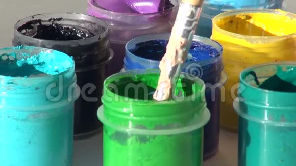 刷子浸在一罐浅绿色丙烯酸沟漆中视频的预览图