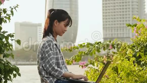 越南亚洲女孩在市中心使用笔记本电脑视频的预览图