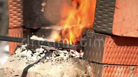这个人把煤混在火里以便锻造投掷临时壁炉里的煤视频的预览图