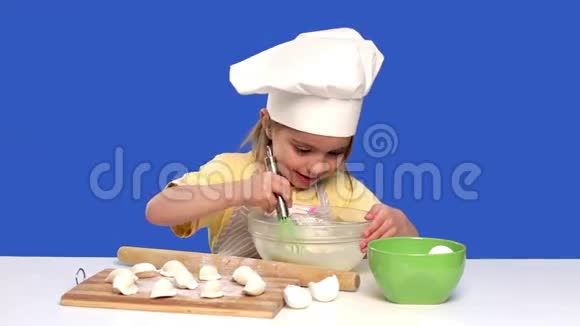 小女孩厨师在蓝色的工作室准备食物概念烹饪视频的预览图