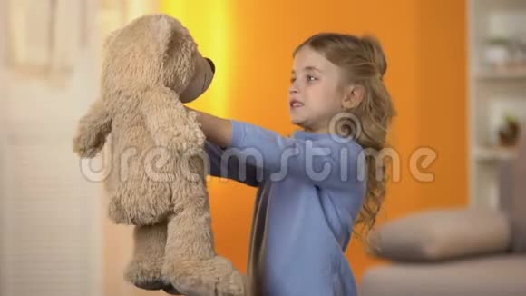 可爱的小女孩看着泰迪熊拥抱它最喜欢的玩具童年视频的预览图