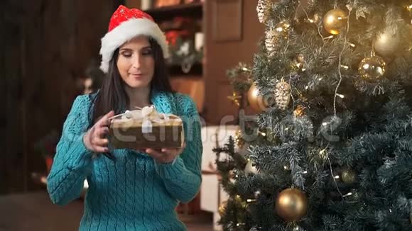 微笑的黑发女人打开圣诞树灯的礼盒视频的预览图