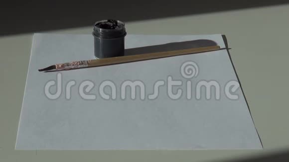 纸刷子和一罐黑色丙烯酸水粉颜料在标签上视频的预览图