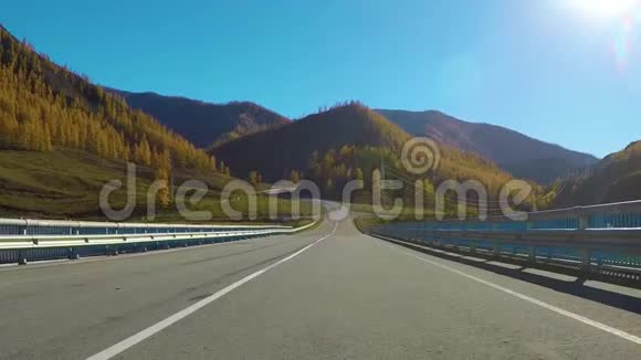 秋天白天开车沿着一条安静的农村公路行驶俄罗斯西伯利亚查斯基地区视频的预览图