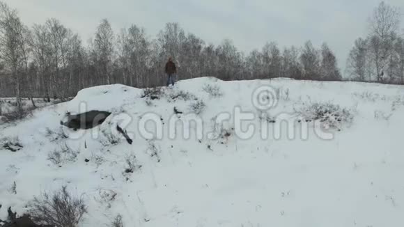 人在白色的冬季森林道路上奔跑俯视无人驾驶飞机的空中镜头希克在山间移动鼓舞人心视频的预览图