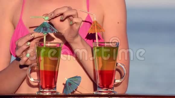 酒吧里穿泳衣的女孩用鸡尾酒装饰背景是大海视频的预览图