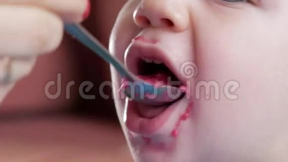 一个2岁有魅力的男孩吃一份红甜菜沙拉面涂抹粥放在桌子上特写视频的预览图