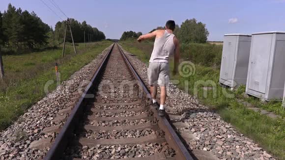 少年走着走着试图在铁轨上平衡视频的预览图