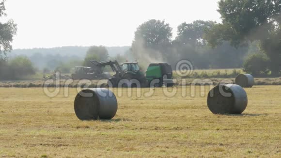 拖拉机在秋天的田野上奔跑把干草堆在捆里视频的预览图