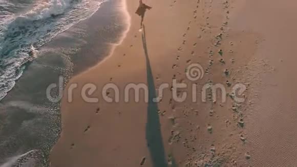 在海边的海边有电话散步的快乐女孩视频的预览图