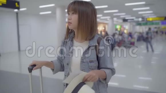 慢动作快乐的亚洲女人使用手推车或手推车许多行李在候机大厅行走视频的预览图