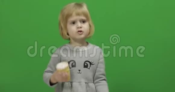 一个女孩在绿色屏幕上放着冰淇淋彩色钥匙视频的预览图