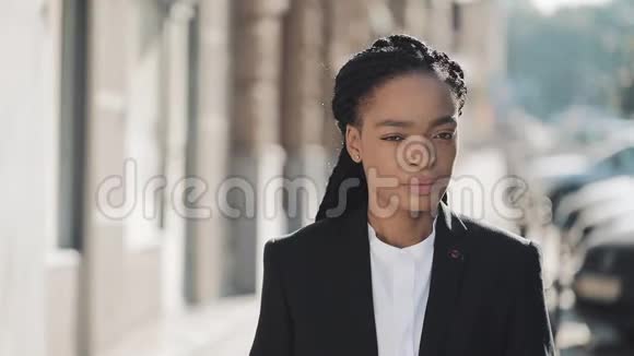 站在老街背景上的时尚非洲商业女性的肖像她看着摄像机黑色时尚视频的预览图