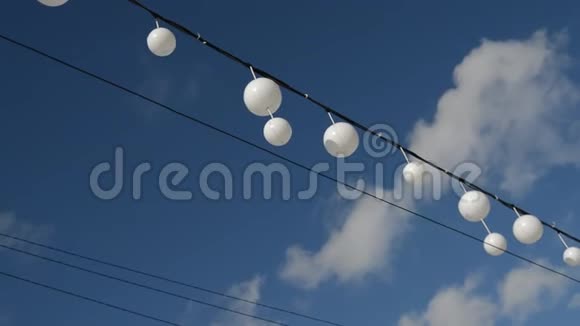 白色的花环气球在风中在蓝天和云彩的映衬下摇摆宁静的风景视频的预览图