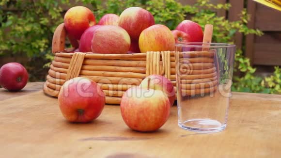 苹果汁和一篮子熟苹果放在木桌上视频的预览图
